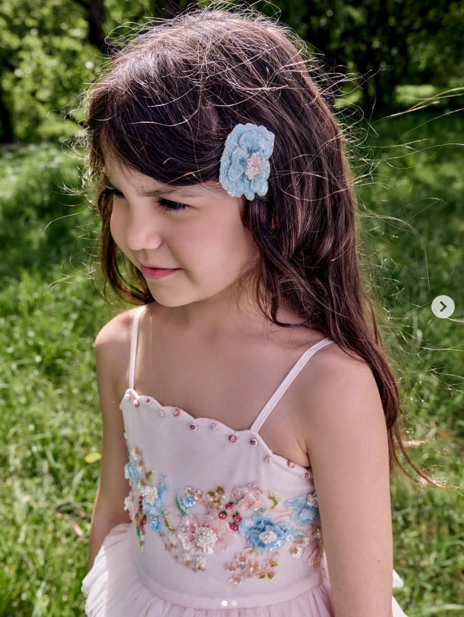 Girl wearing the Blue Rosette Clip flower hair accessory by House of Carousél
