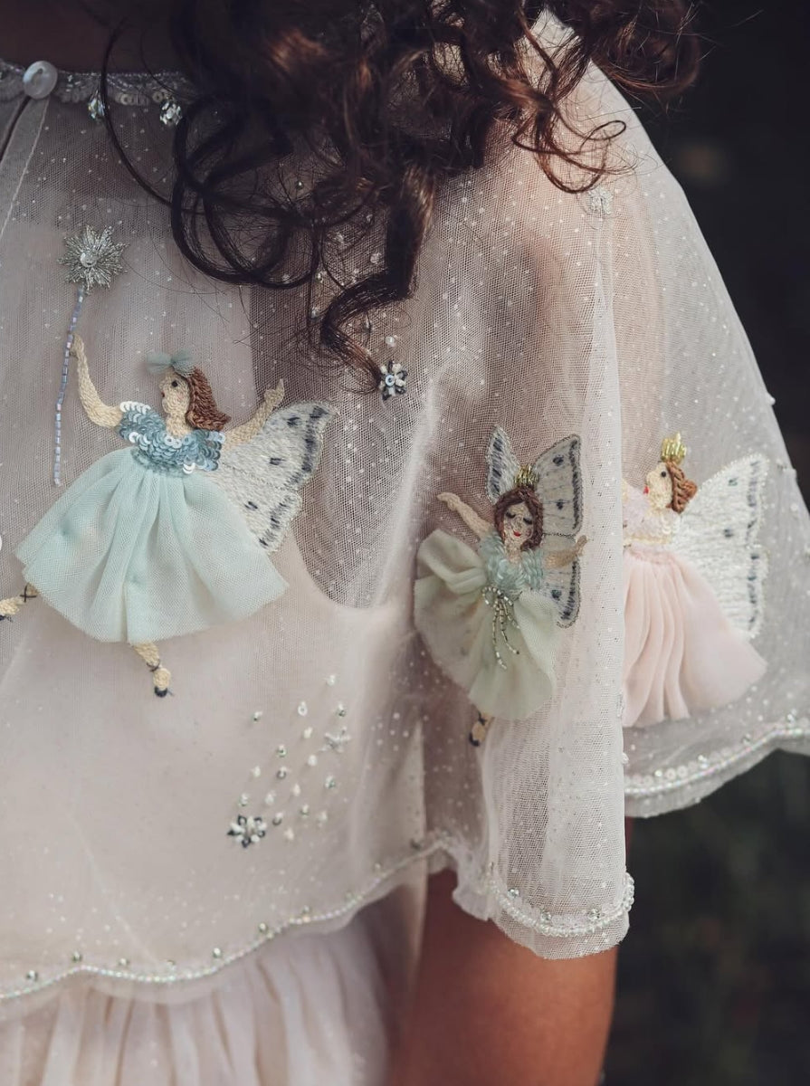 Detail of sheer fairy cape and hand-appliquéd embellishments on girls dress by House of Carousel