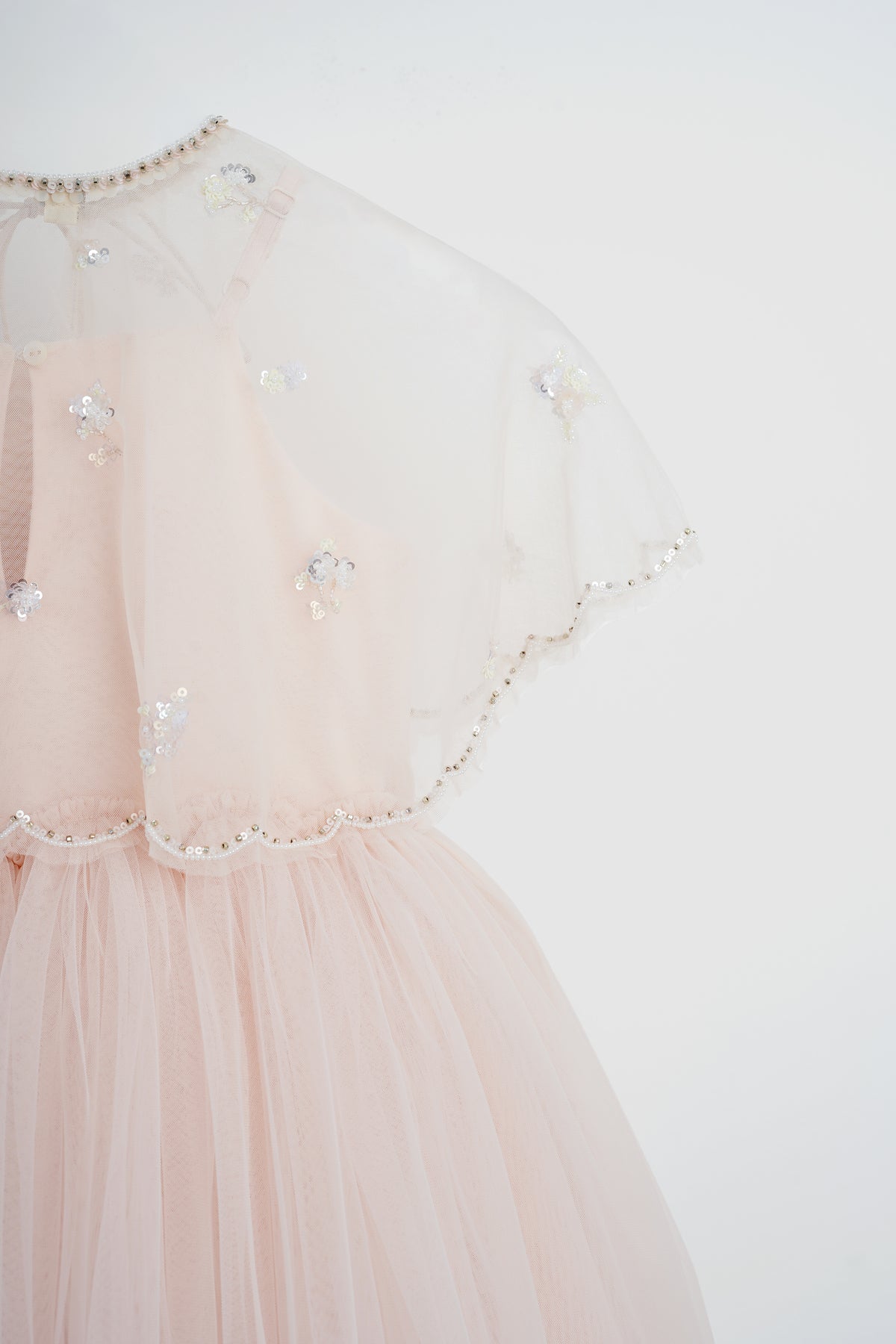 Side detail of Fairy by Herself Dress with sheer cape and layered pink tulle skirt