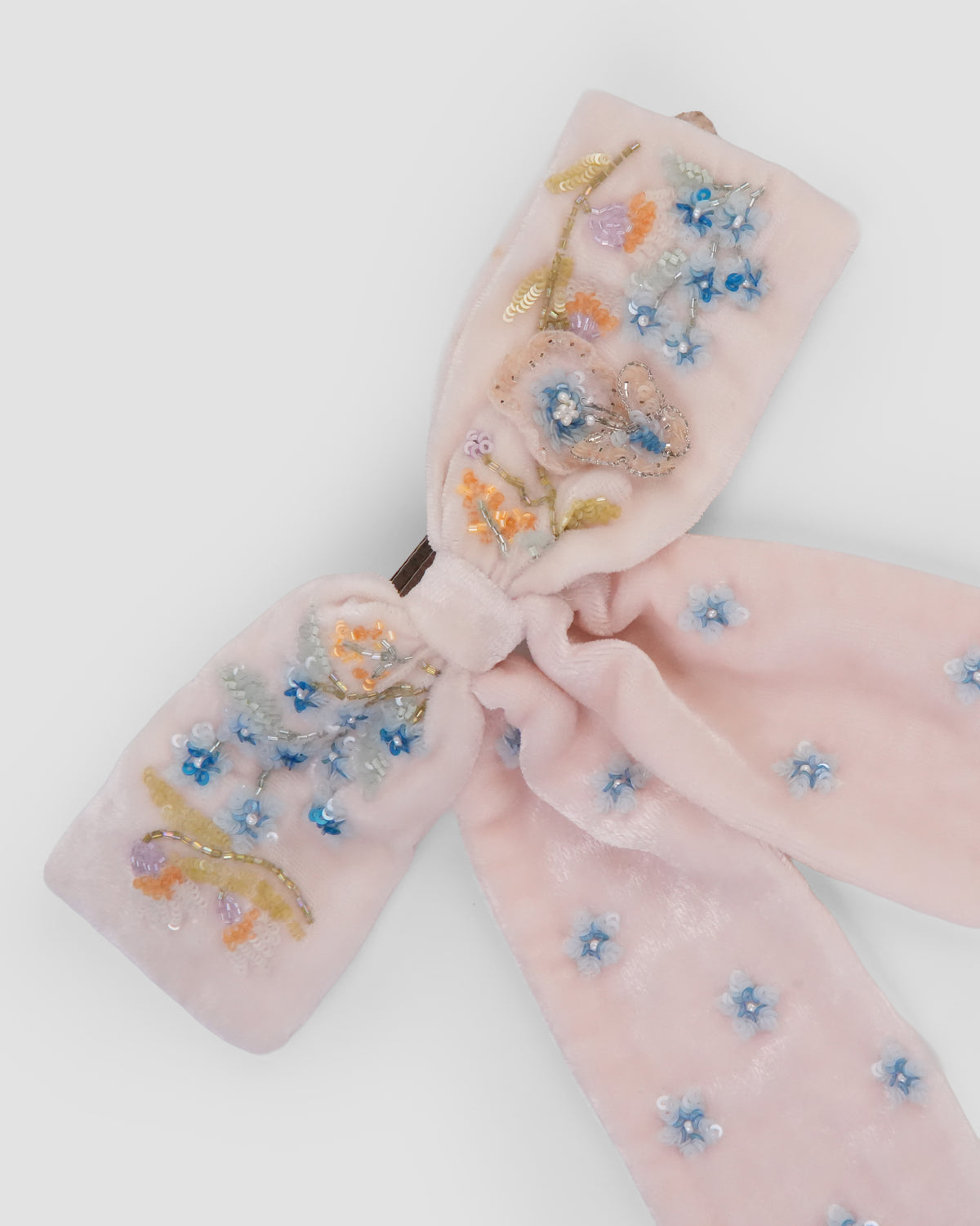 Close-up of Fleur de Velvet Bow with hand-embroidered floral sprays and long velvet tails