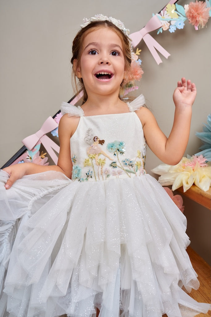 Girl wearing the Hydrangea Fairy Dress with hand-appliquéd fairy and hydrangea details by House of Carousel available at House of Aura