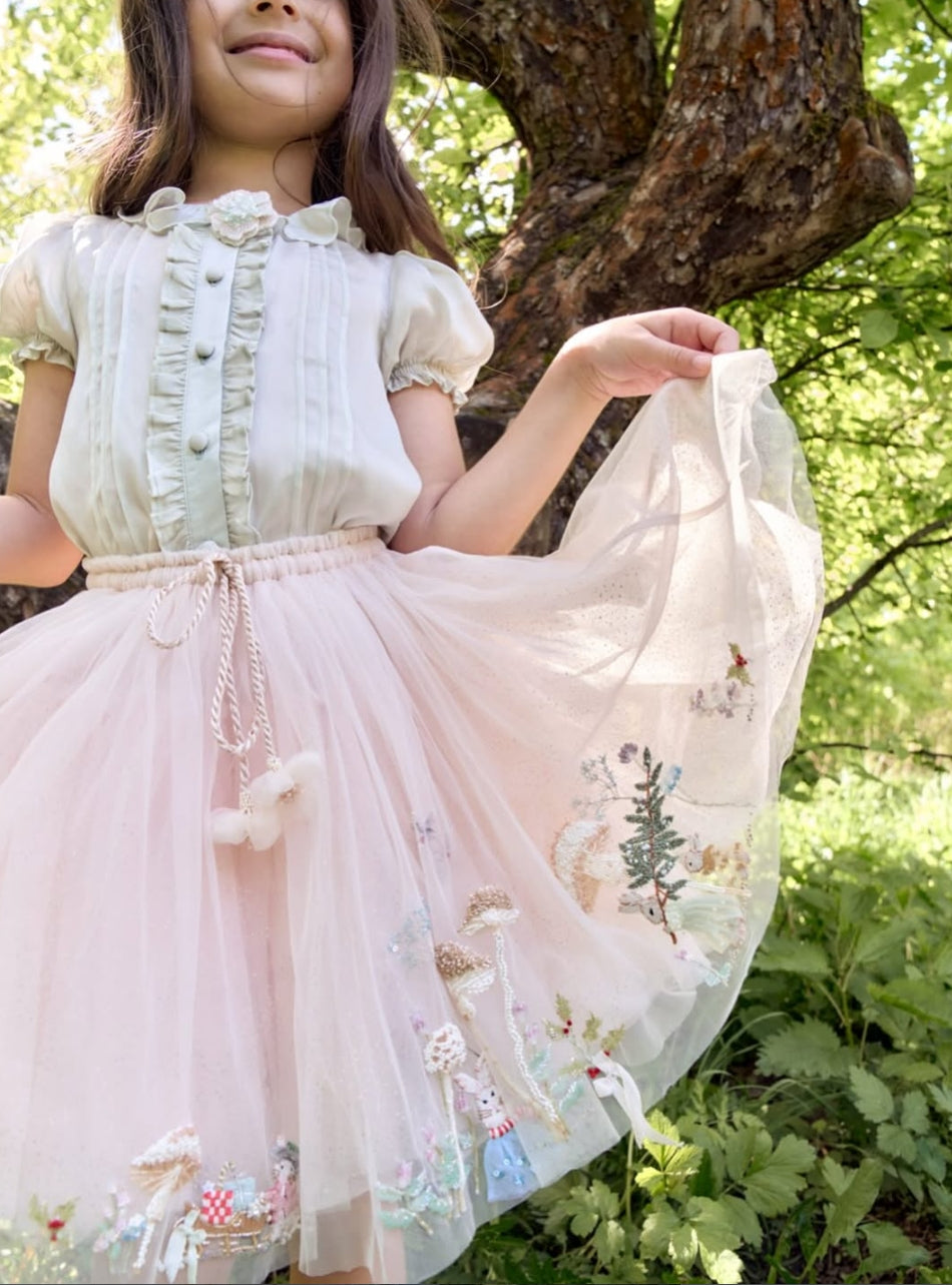 Girl wearing the Tales of the Bunny Parade blouse and embroidered tutu skirt set by House of Carousél