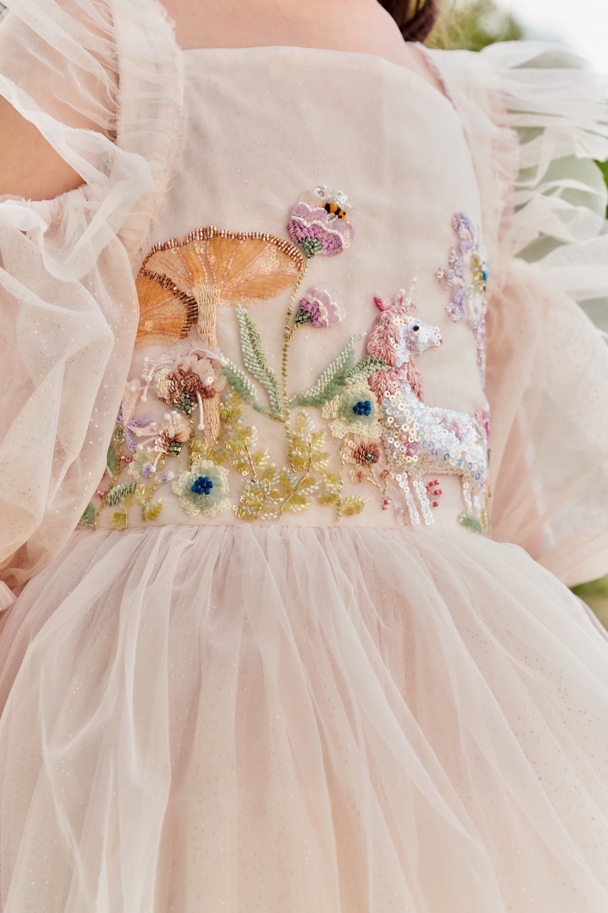 Close-up of unicorn, floral and bee embroidery on Unicorn Meadow Dress by House of Carousél